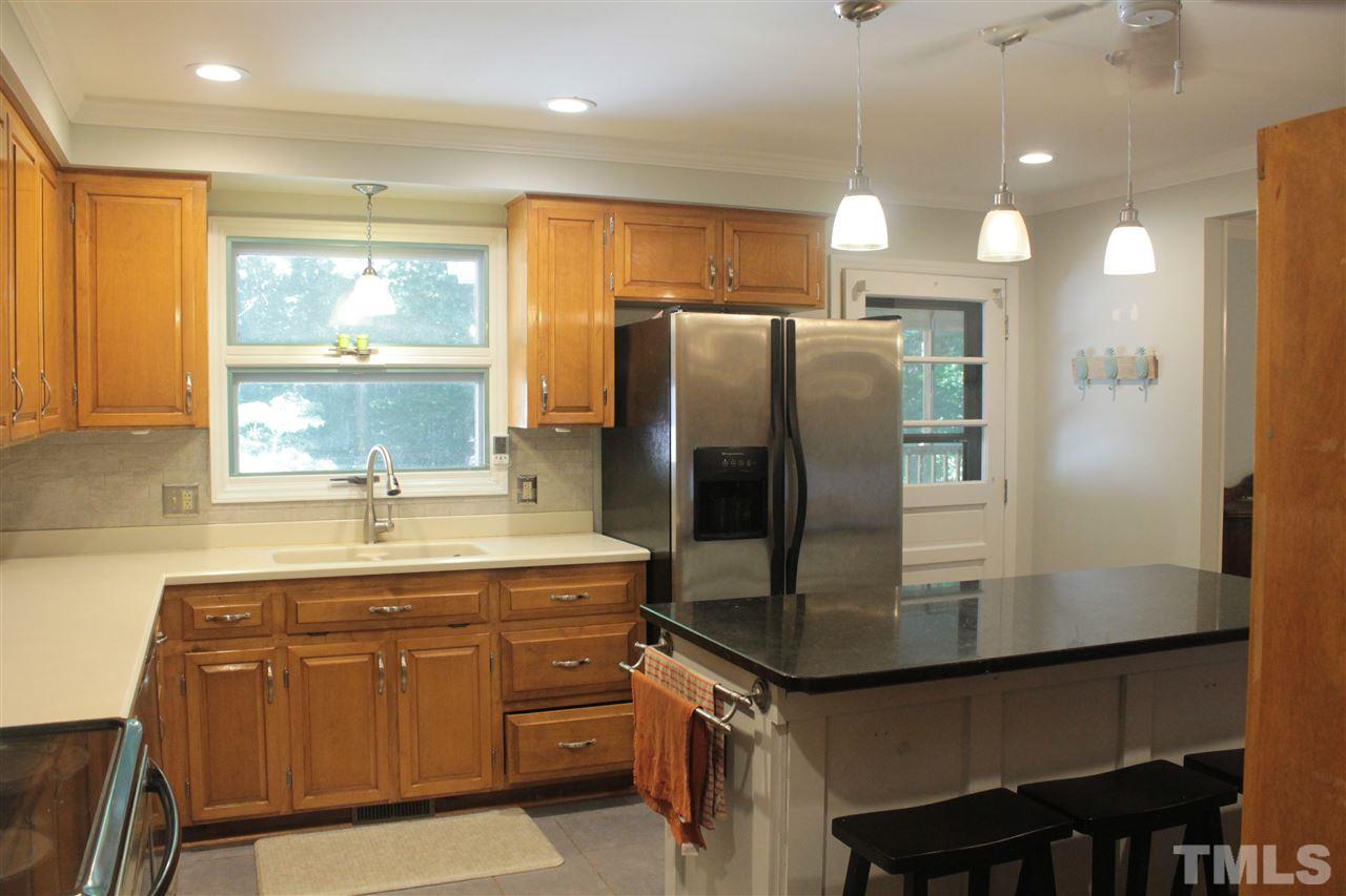9621 Rock Creek Road Raleigh, NC 27613 - Photo 4 of 15 a kitchen with kitchen island a sink stove and refrigerator