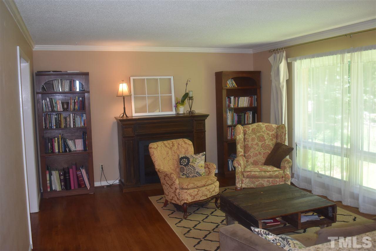 9621 Rock Creek Road Raleigh, NC 27613 - Photo 6 of 15 a living room with furniture fireplace and book shelf
