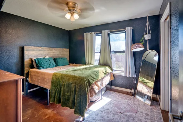 a bedroom with a bed lamp and a large window