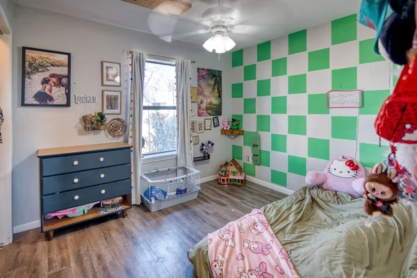 a bedroom with a bed and a wooden floor