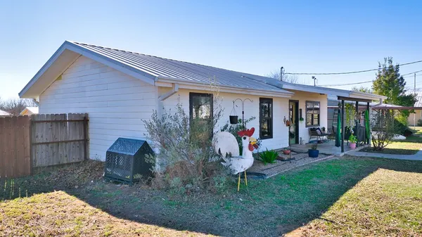 a view of a house with backyard and sitting area