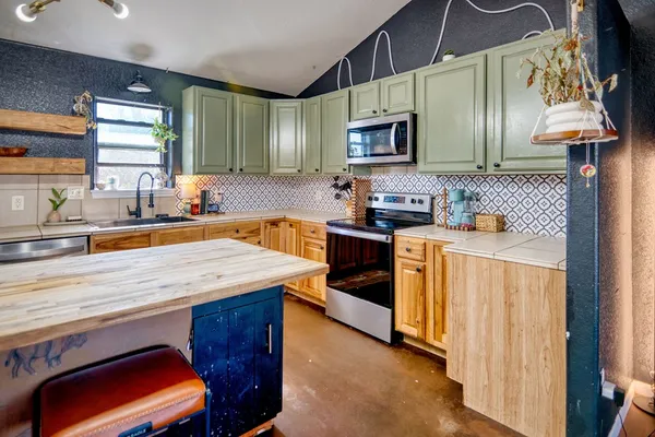 a kitchen with stainless steel appliances a sink stove and microwave