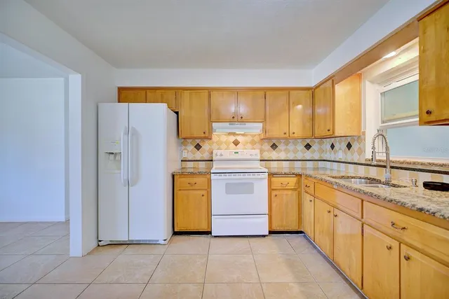 a kitchen with a refrigerator sink and cabinets