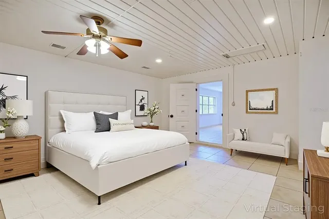 a bedroom with a large bed and a chandelier