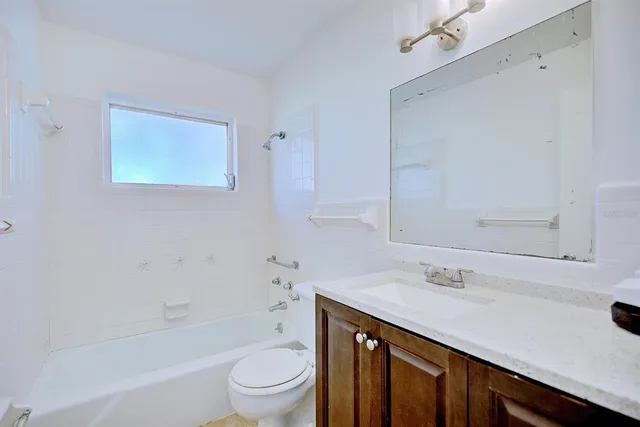 a bathroom with a sink a toilet a mirror and bathtub