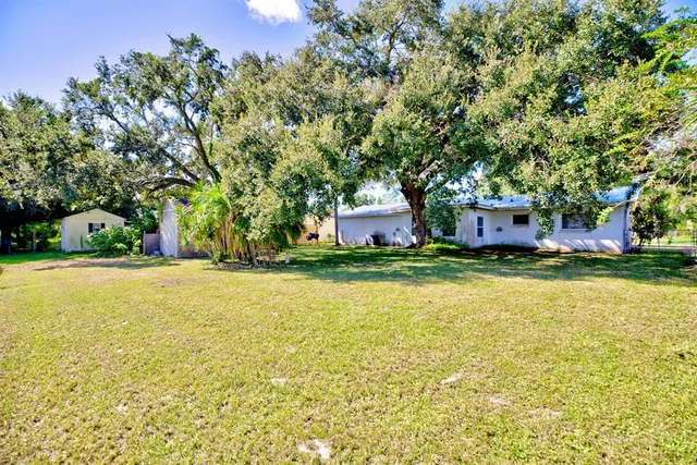 a front view of a house with swimming pool and green space