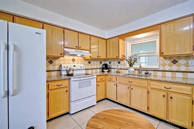 a kitchen with stainless steel appliances a sink cabinets and a window