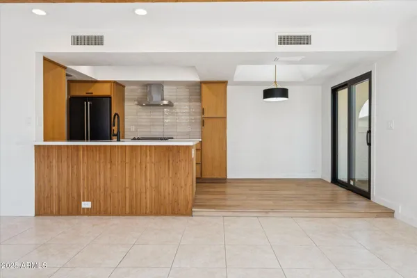 a view of a kitchen with wooden cabinets and an empty room