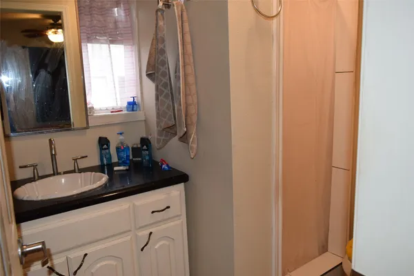 a bathroom with a granite countertop sink and a mirror
