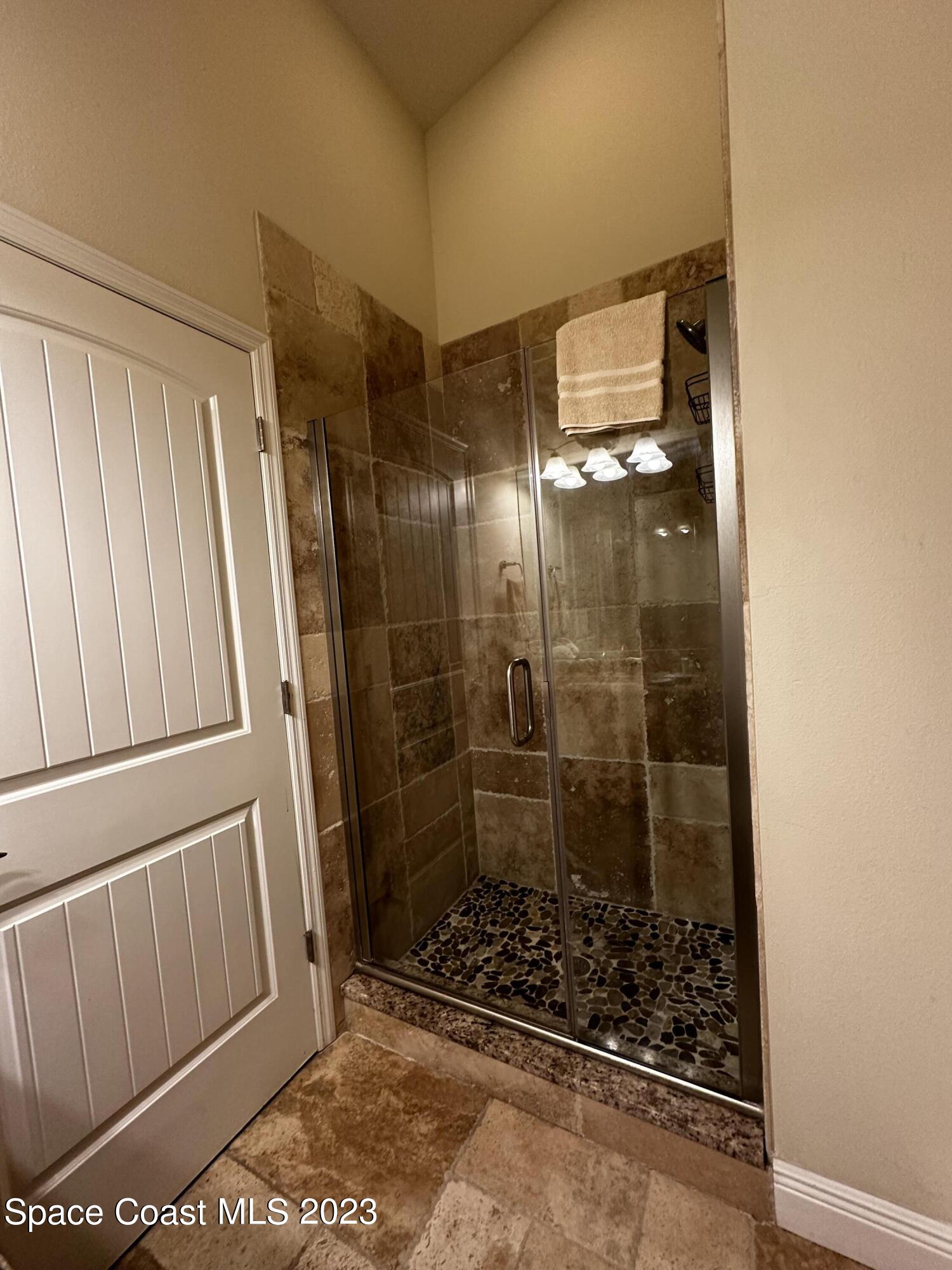 103 Parrotfish Lane, Unit 101 Merritt Island, FL 32953 - Photo 12 of 19 a bathroom with a glass shower door