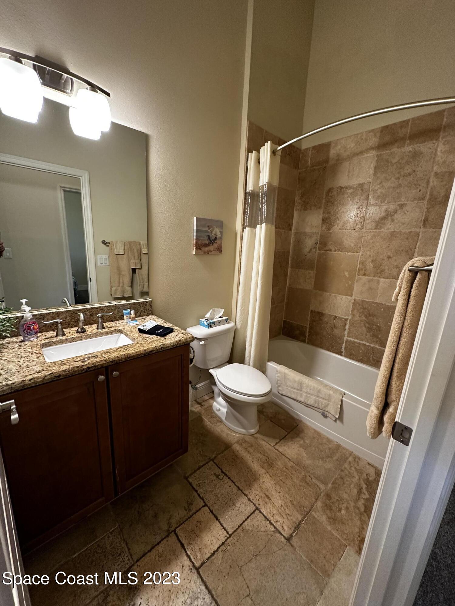 103 Parrotfish Lane, Unit 101 Merritt Island, FL 32953 - Photo 17 of 19 a bathroom with a double vanity sink toilet and shower