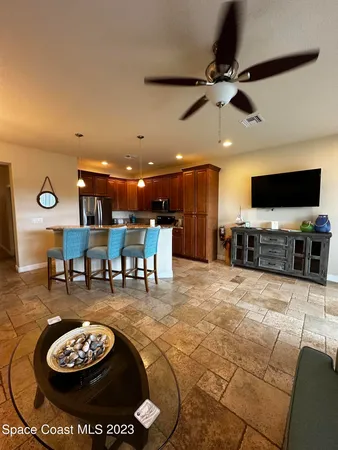 a living room with furniture and a flat screen tv with kitchen view