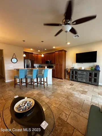 a living room with furniture and a flat screen tv with kitchen view