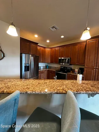 a kitchen with kitchen island granite countertop a stove and a sink