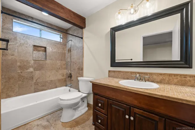 a bathroom with a toilet a sink a bathtub and a mirror