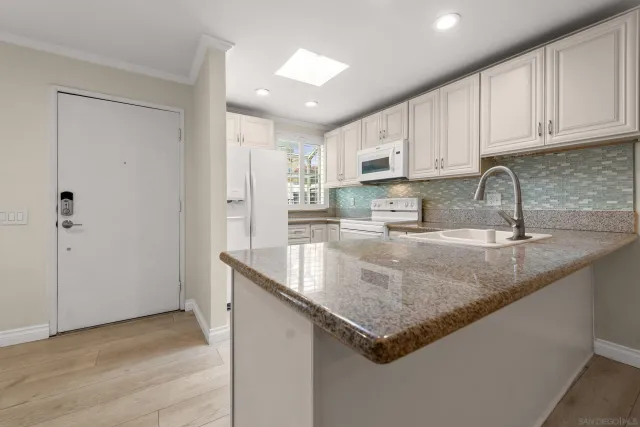 a kitchen with stainless steel appliances granite countertop a sink a refrigerator and a granite counter tops