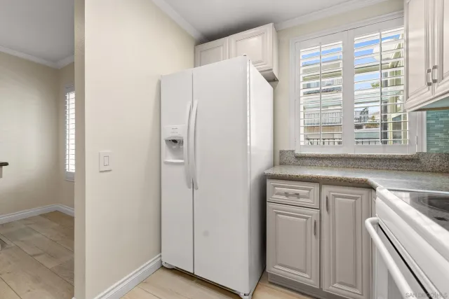 a kitchen with a white cabinets and a refrigerator