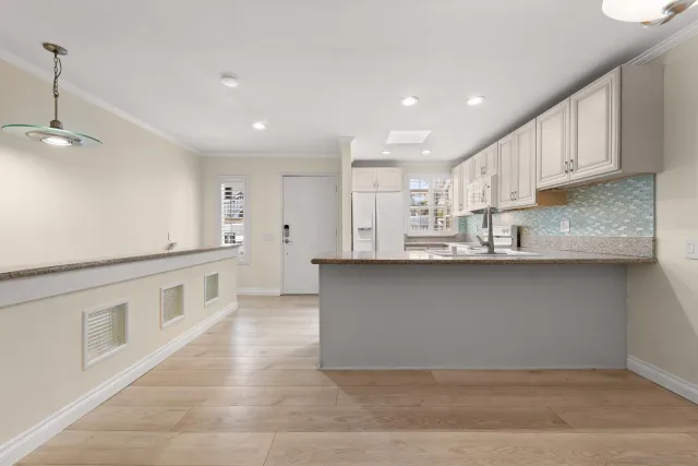 a kitchen with stainless steel appliances granite countertop a sink and white cabinets