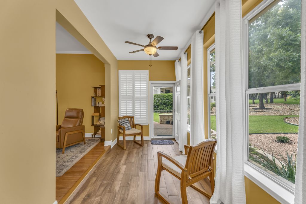 144 Cattle Trail Way Georgetown, TX 78633 - Photo 12 of 37 A naturally illuminated sunroom with warm hardwood flooring and expansive views of the landscaped yard.