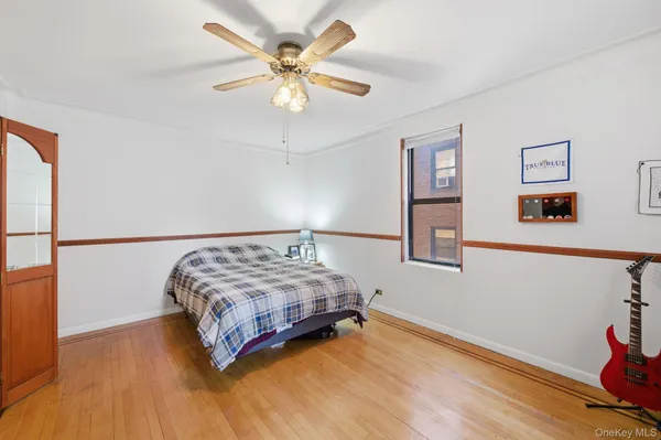 a bedroom with a bed chandelier and a window