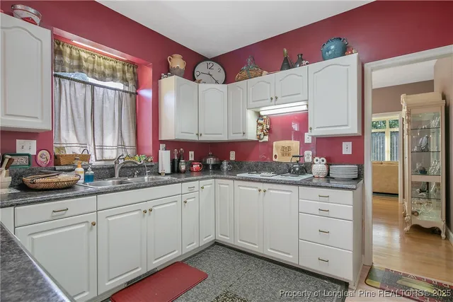 a kitchen with white cabinets and sink
