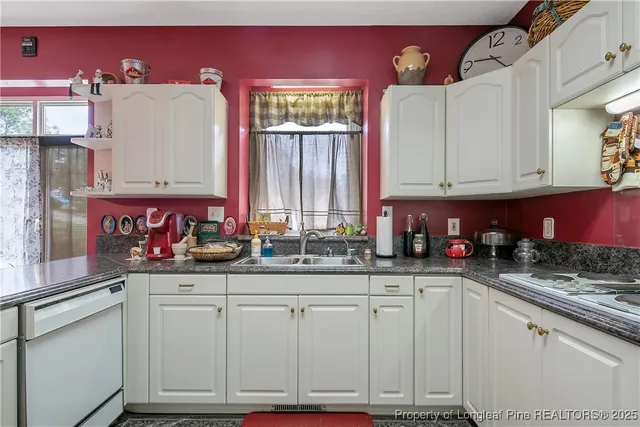 a kitchen with granite countertop a sink and cabinets