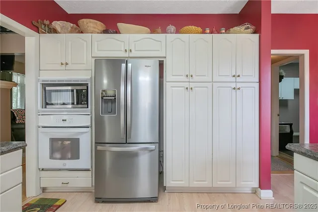 a kitchen with white cabinets and stainless steel appliances