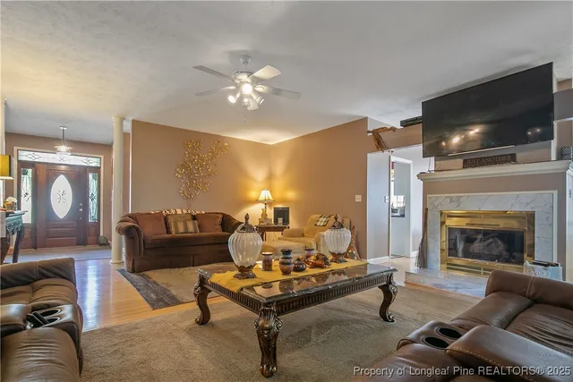 a living room with furniture a flat screen tv and a fireplace