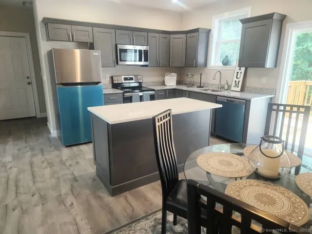 a kitchen with a sink a table and chairs