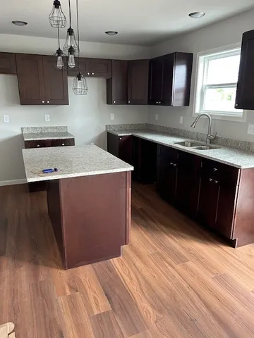 a kitchen with stainless steel appliances granite countertop a sink a stove a refrigerator and cabinets