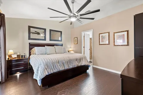 a bedroom with a large bed and a ceiling fan