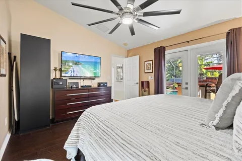 a bedroom with a bed and a flat tv screen on dresser