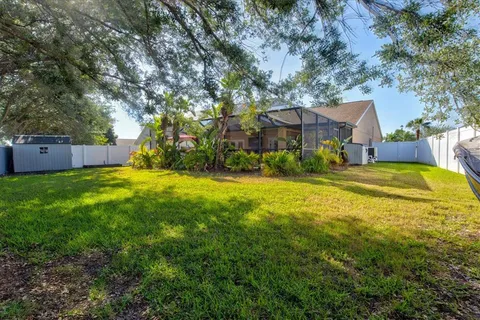a view of a big house with a big yard and large tree