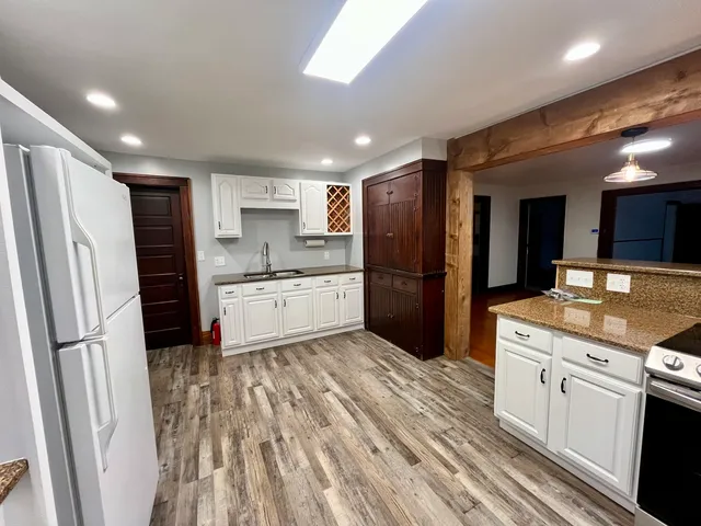 a kitchen with stainless steel appliances granite countertop a refrigerator and a stove top oven