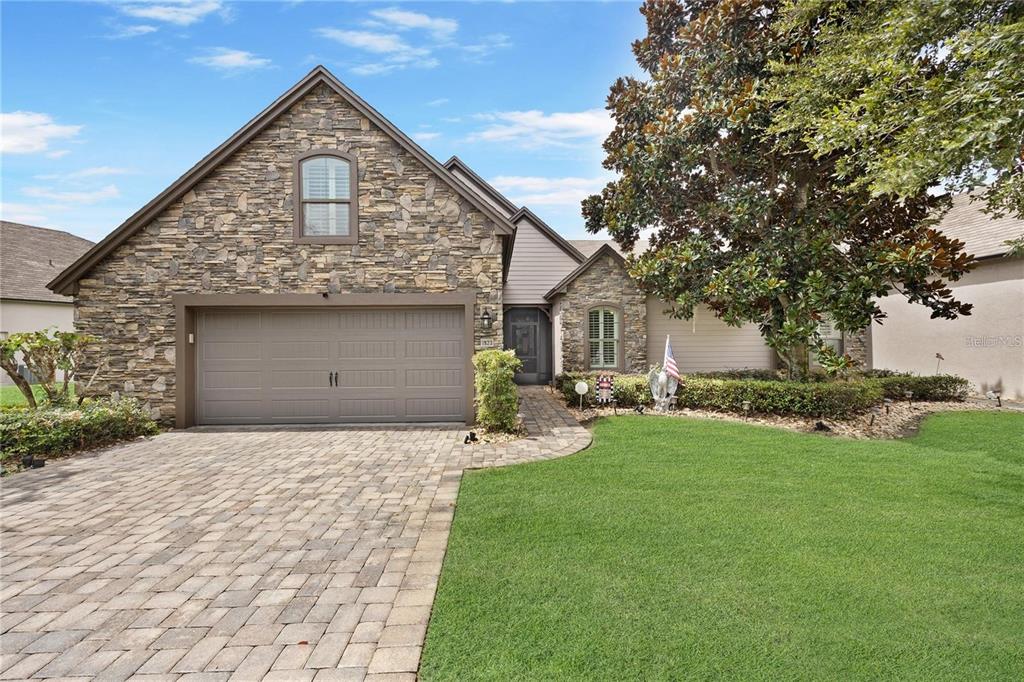 a front view of a house with a garden and yard