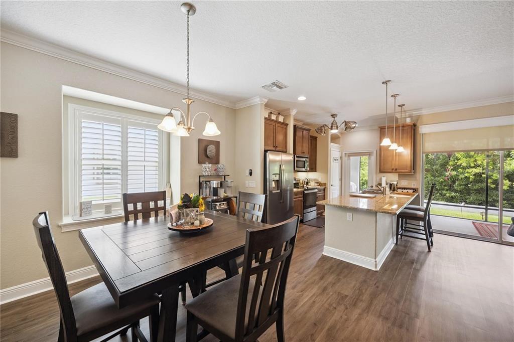 1923 Banning Beach Road Tavares, FL 32778 - Photo 14 of 44 a dining room with wooden floor a chandelier a wooden table and chairs