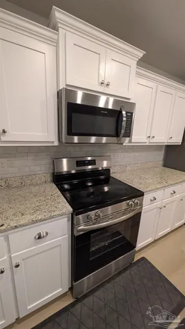 a kitchen with granite countertop cabinets stainless steel appliances and a sink