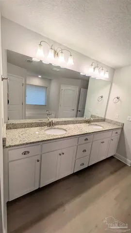 a bathroom with a granite countertop sink and a mirror