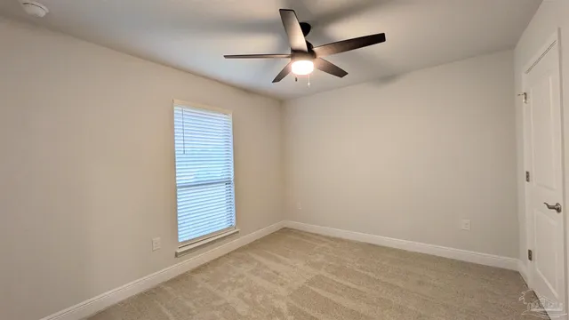 an empty room with a window and ceiling fan