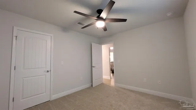 an empty room with closet and a chandelier fan