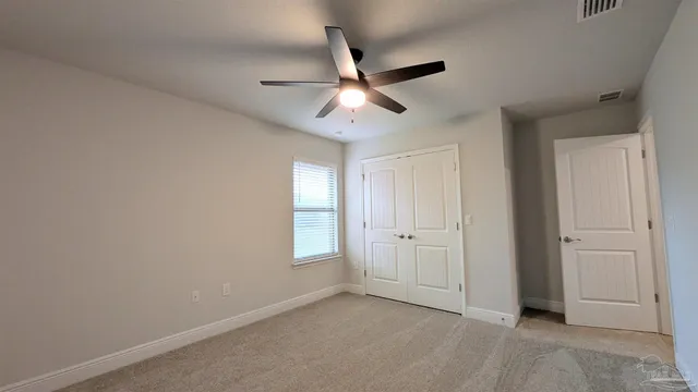 an empty room with closet and windows