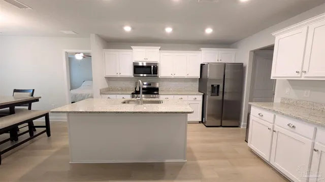 a kitchen with stainless steel appliances a refrigerator a sink a stove a microwave and cabinets