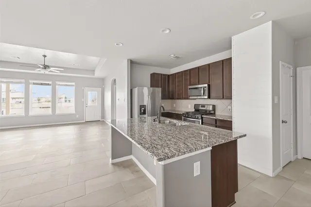 a kitchen with stainless steel appliances granite countertop a sink stove and refrigerator