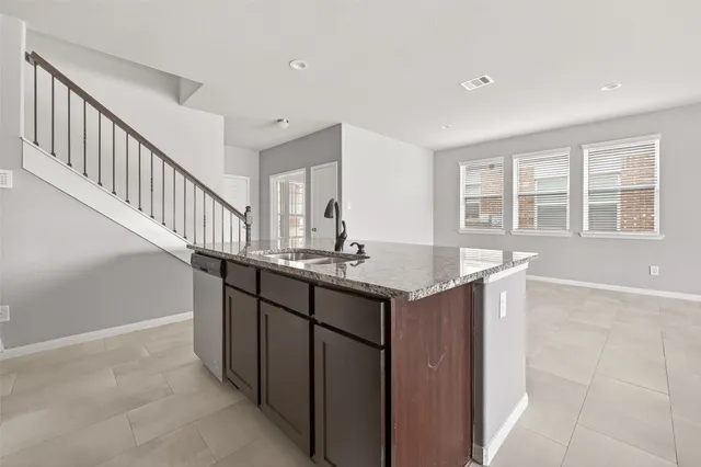 a kitchen with kitchen island a sink and wooden cabinets