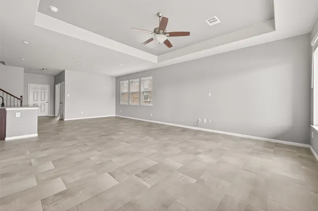 a view of an empty room and kitchen view