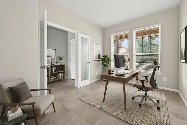 a view of a workspace with furniture and a window