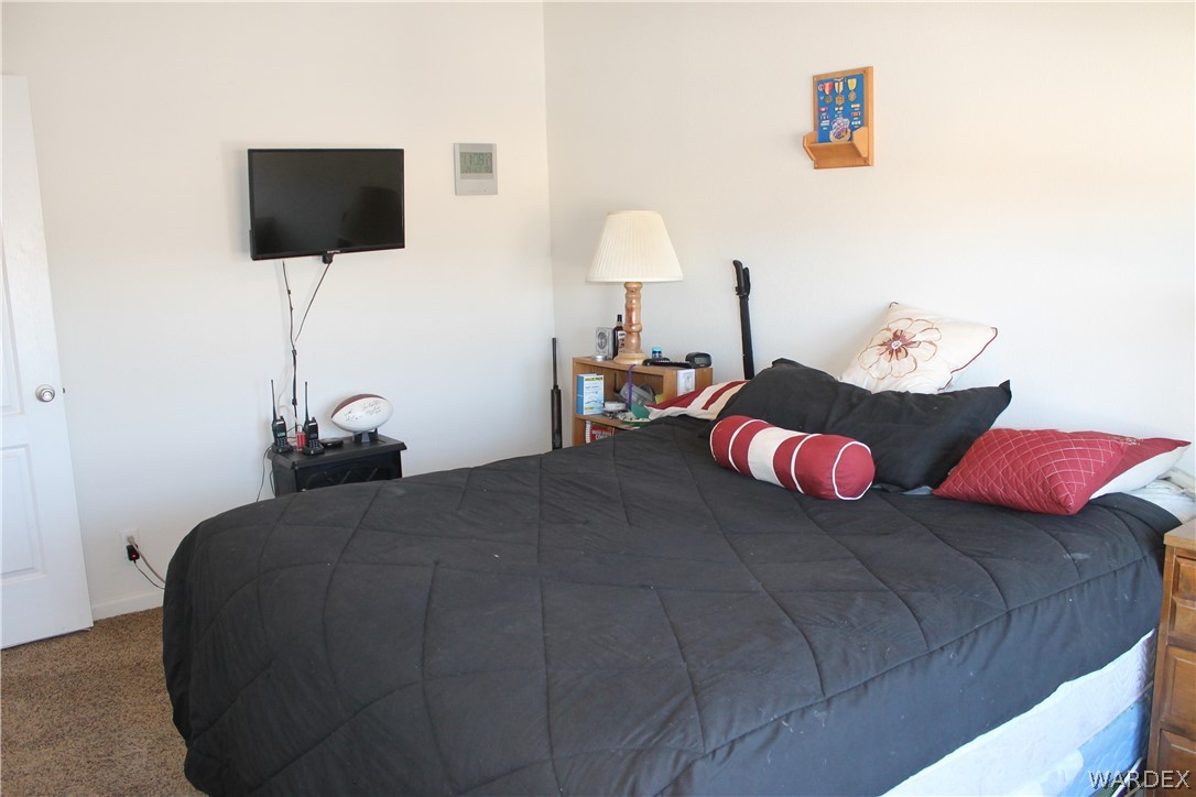 4198 Estrella Road Golden Valley, AZ 86413 - Photo 7 of 50 a bedroom with a bed and a flat screen tv