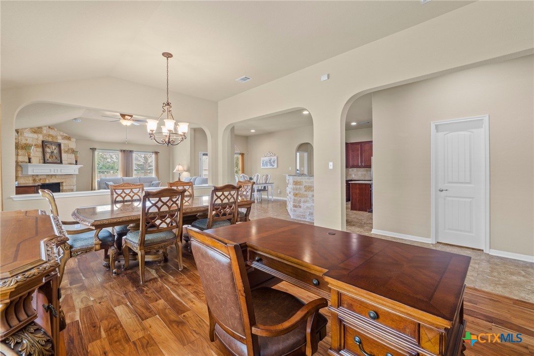 20525 Jackies Ranch Boulevard Pflugerville, TX 78660 - Photo 11 of 30 Dining area with chandelier and study with arched walkways. Acacia wood engineered flooring