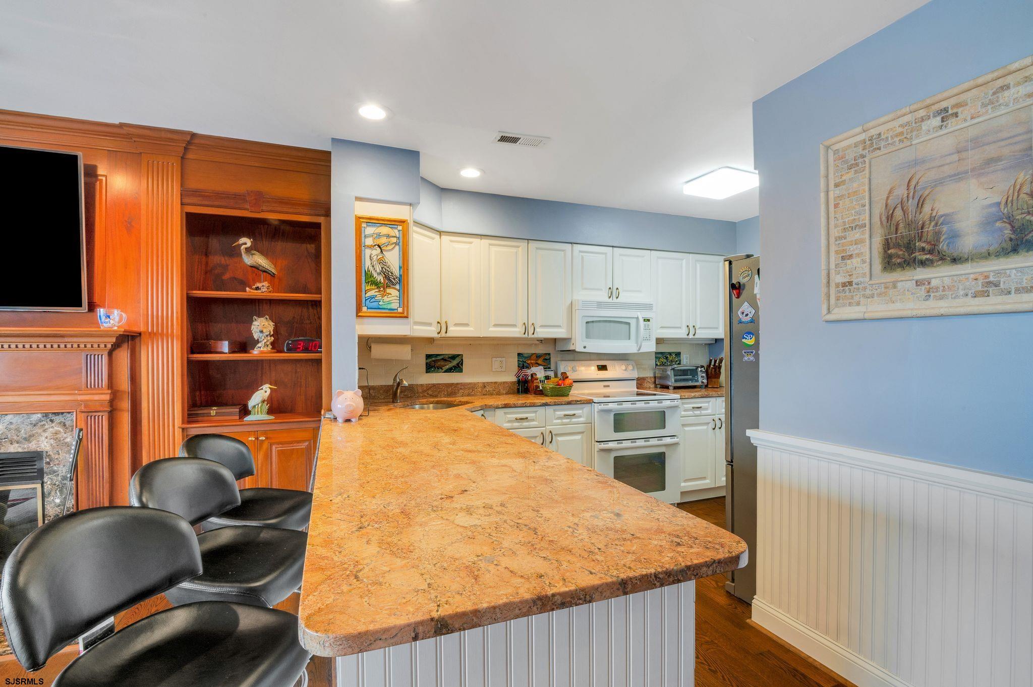504 Harbour Cove, Unit 504 Somers Point, NJ 08244 - Photo 11 of 30 a kitchen with stainless steel appliances granite countertop a refrigerator a stove and a wooden cabinets