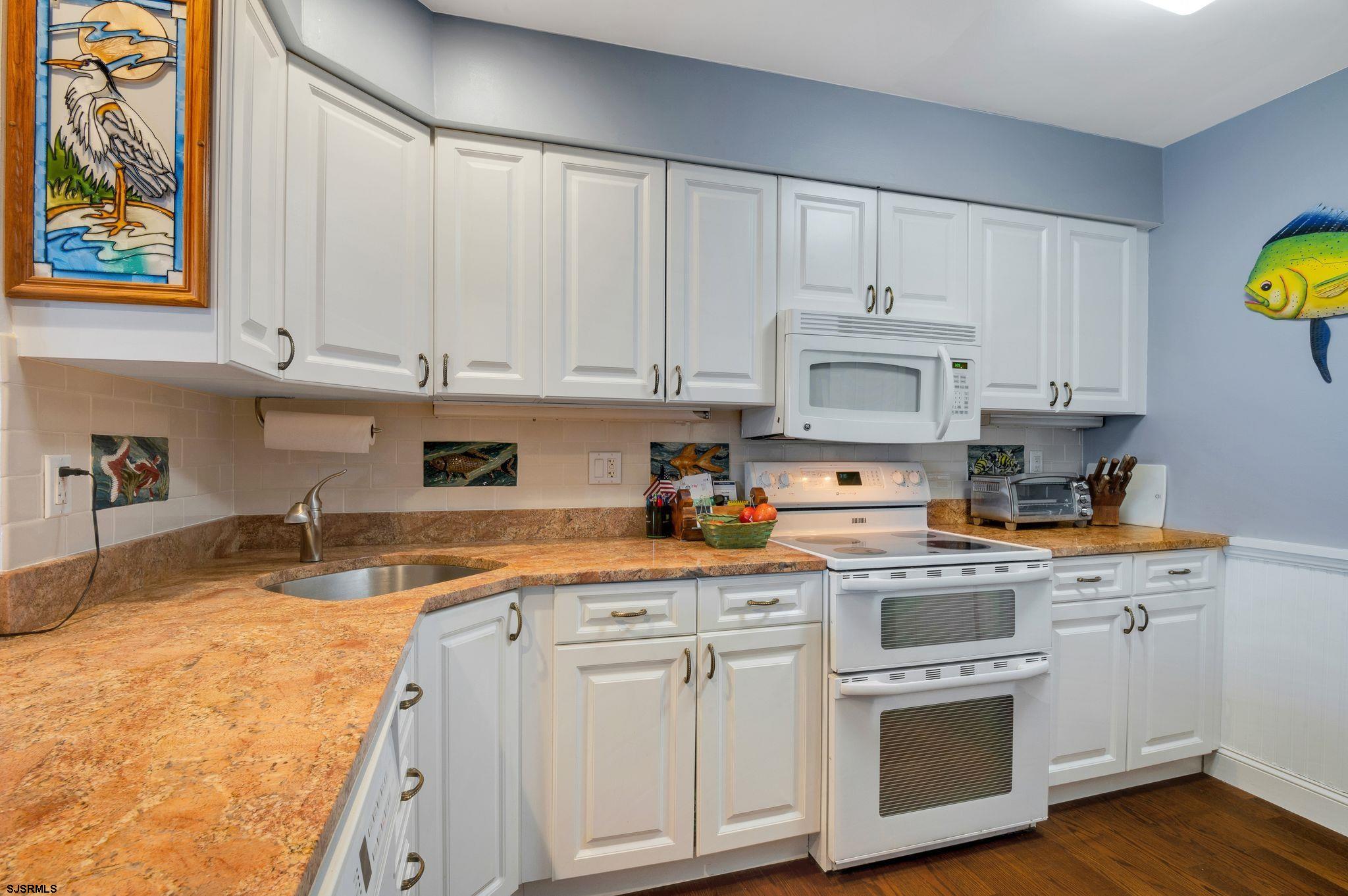 504 Harbour Cove, Unit 504 Somers Point, NJ 08244 - Photo 10 of 30 a kitchen with granite countertop white cabinets and white appliances